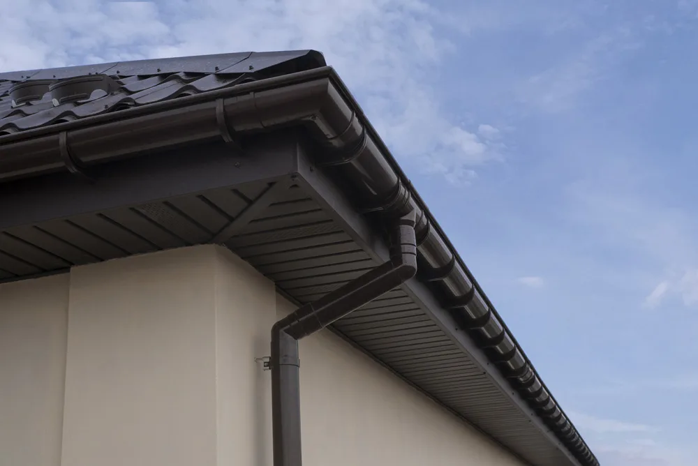 Brown plastic rain gutter system on a house