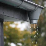 Closeup shot of water drops falling from rain gutters