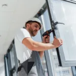 In grey uniform Repairman is working indoors in the modern room
