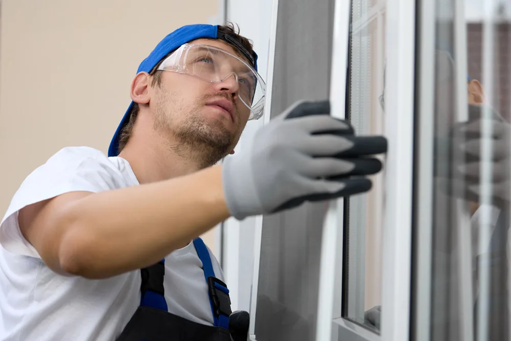 Experienced window installer installing a grid on a plastic window