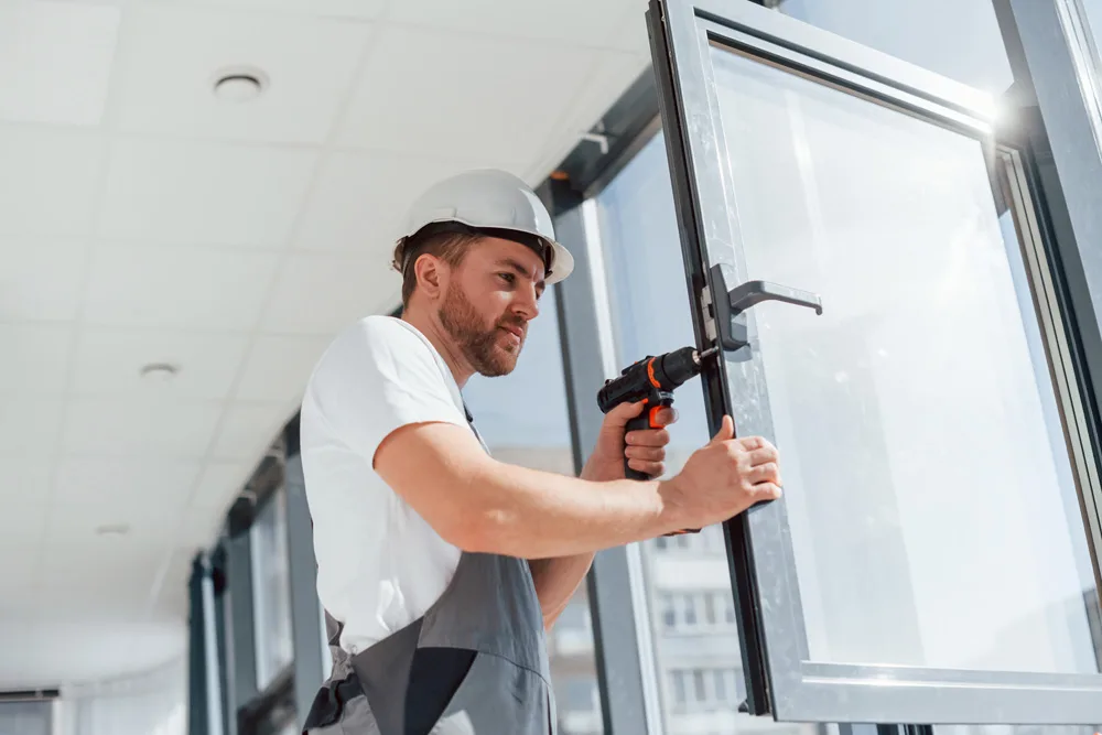 In grey uniform Repairman is working indoors in the modern room