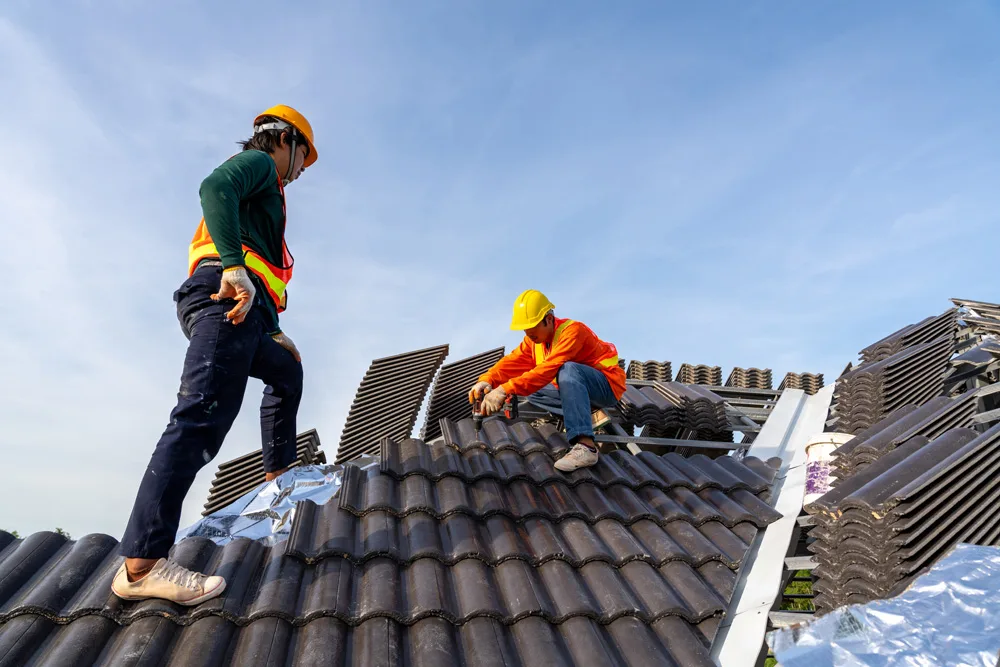 Construction workers install new roof at construction site, El